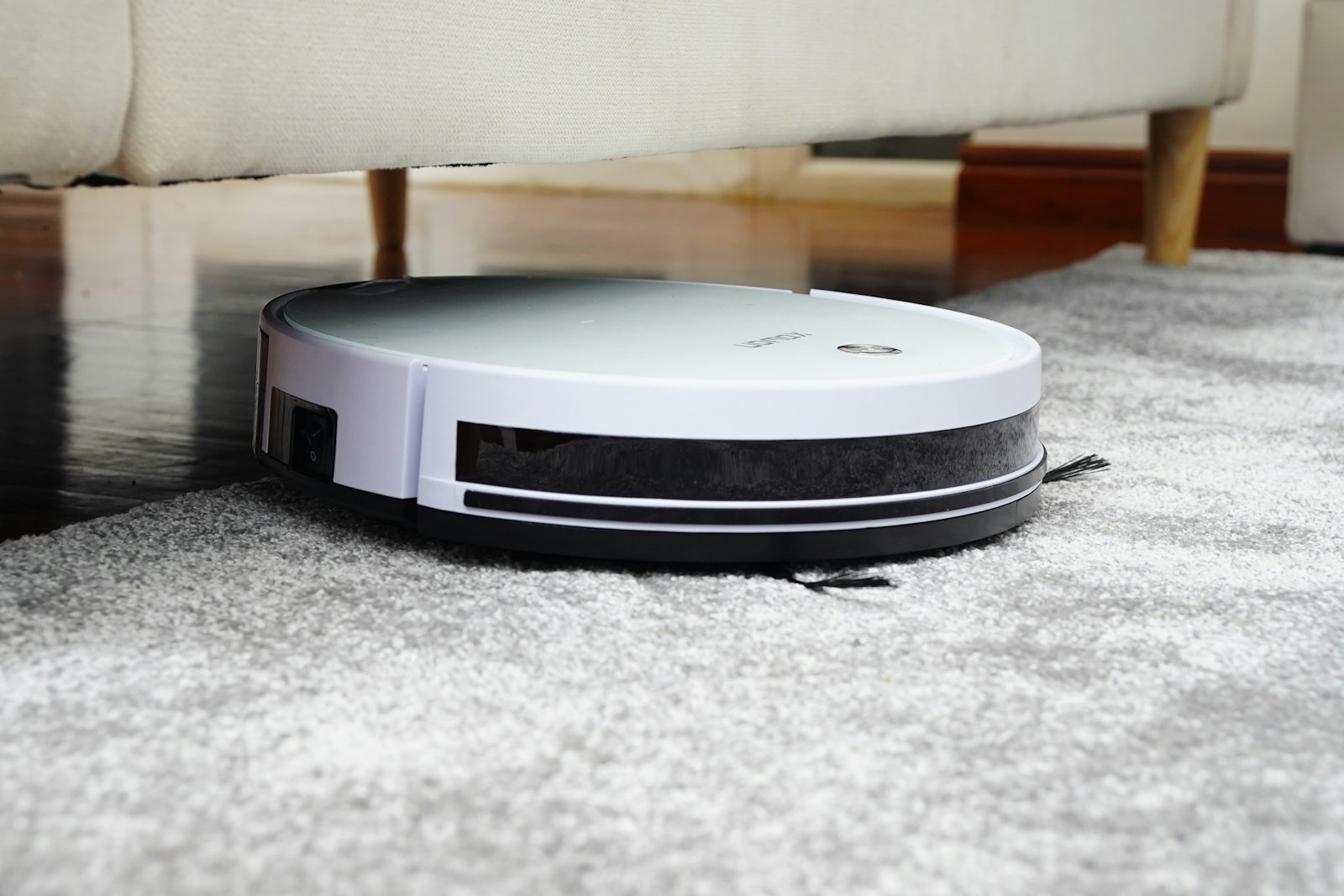 A cordless vacuum cleaning a bright hardwood living area