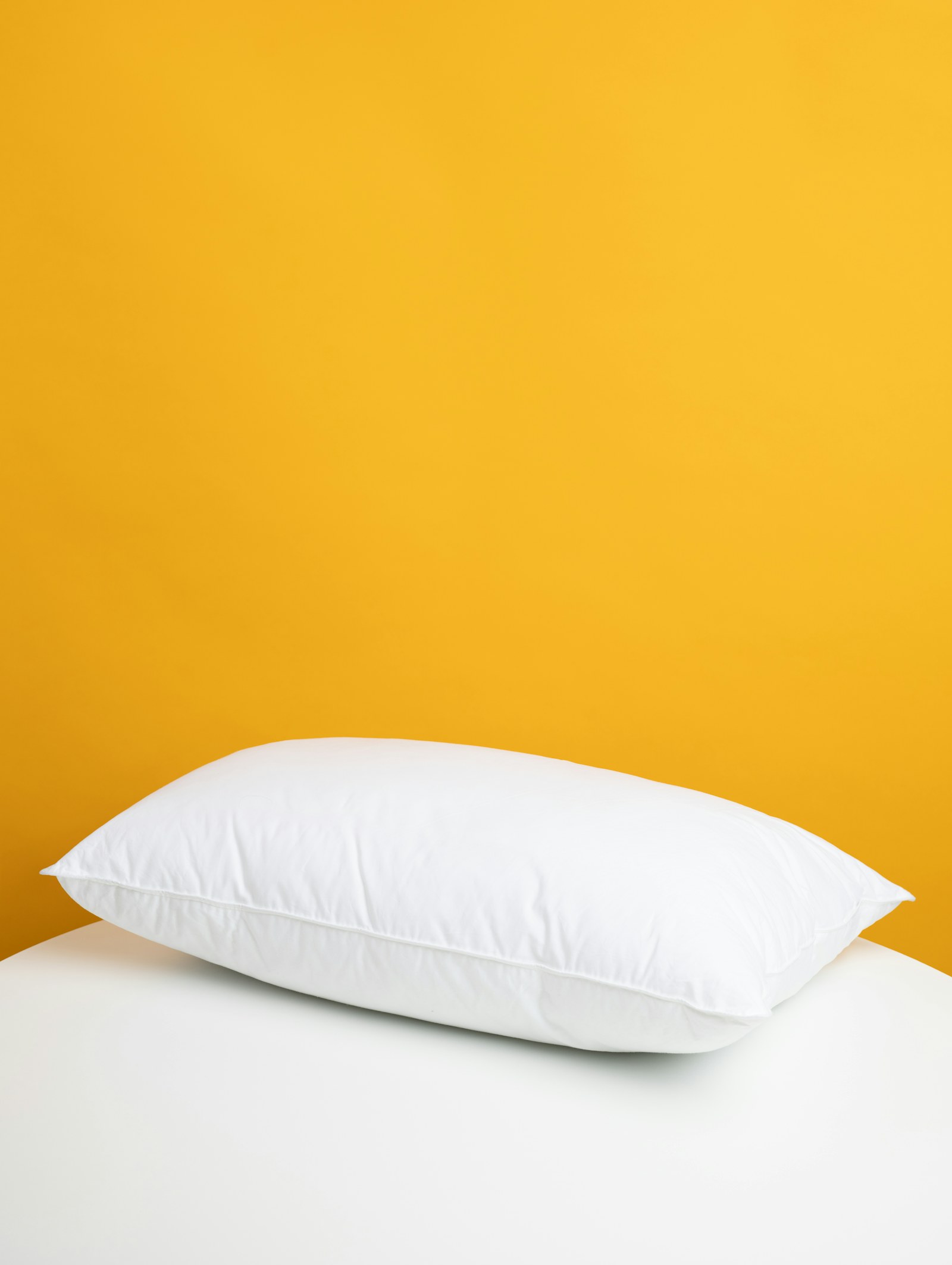 Layered pillows on a calm bed in a bright bedroom