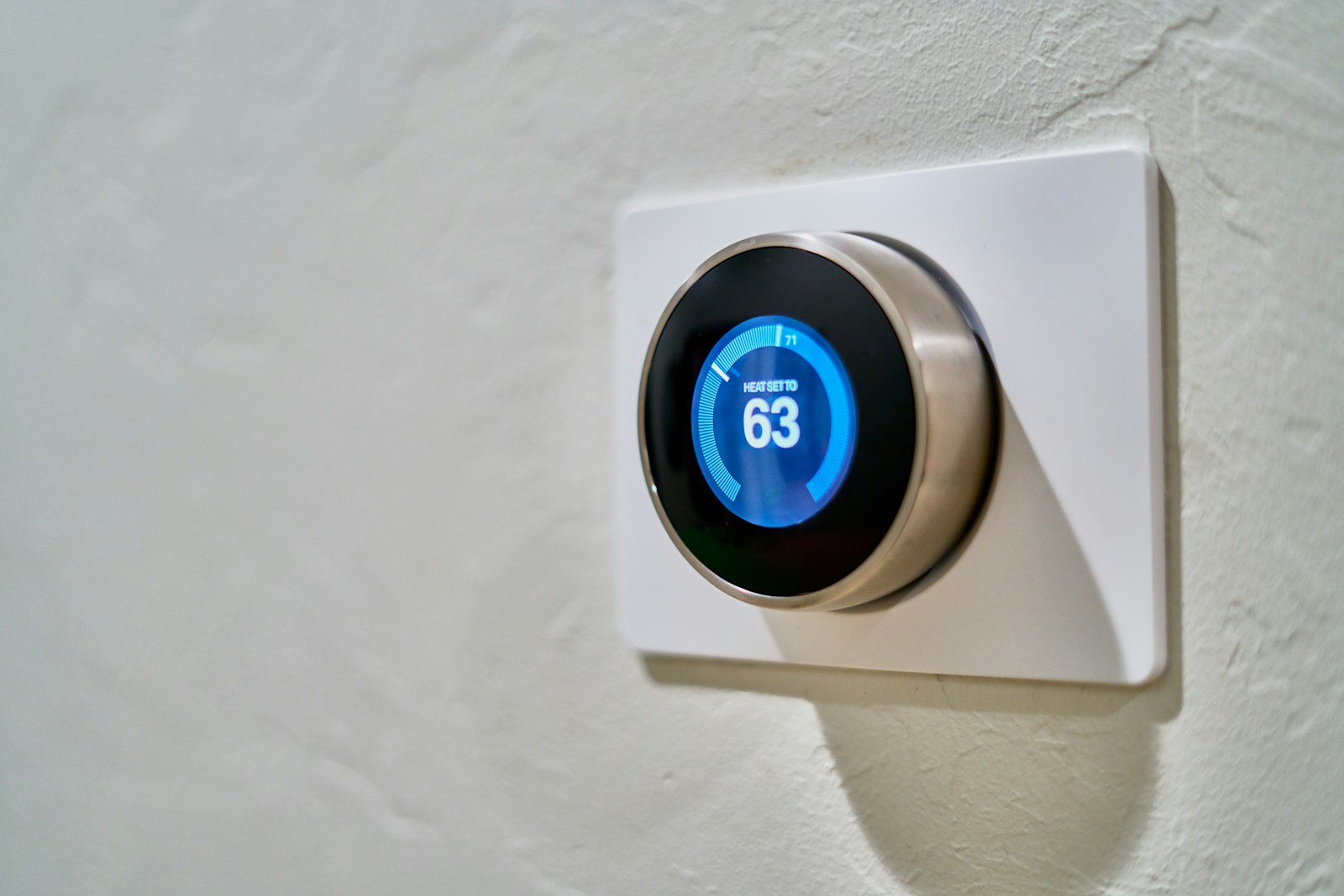 A hallway in an older home with a small wall thermostat